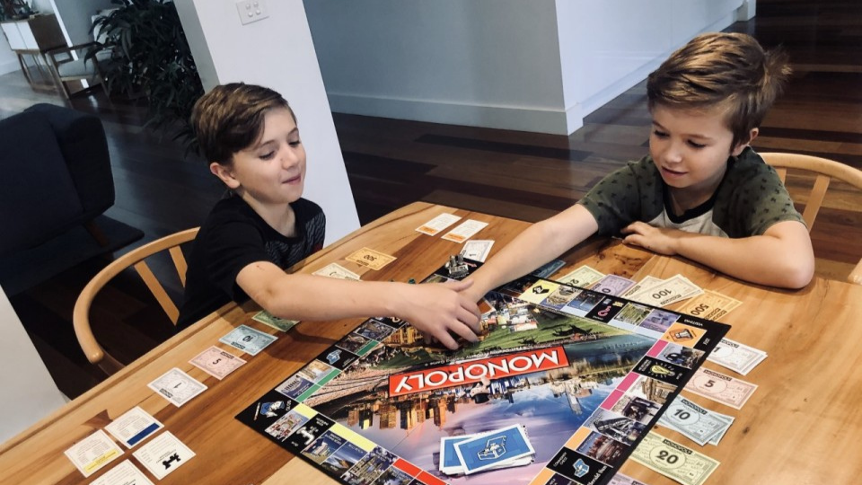 Two kids playing monopoly together