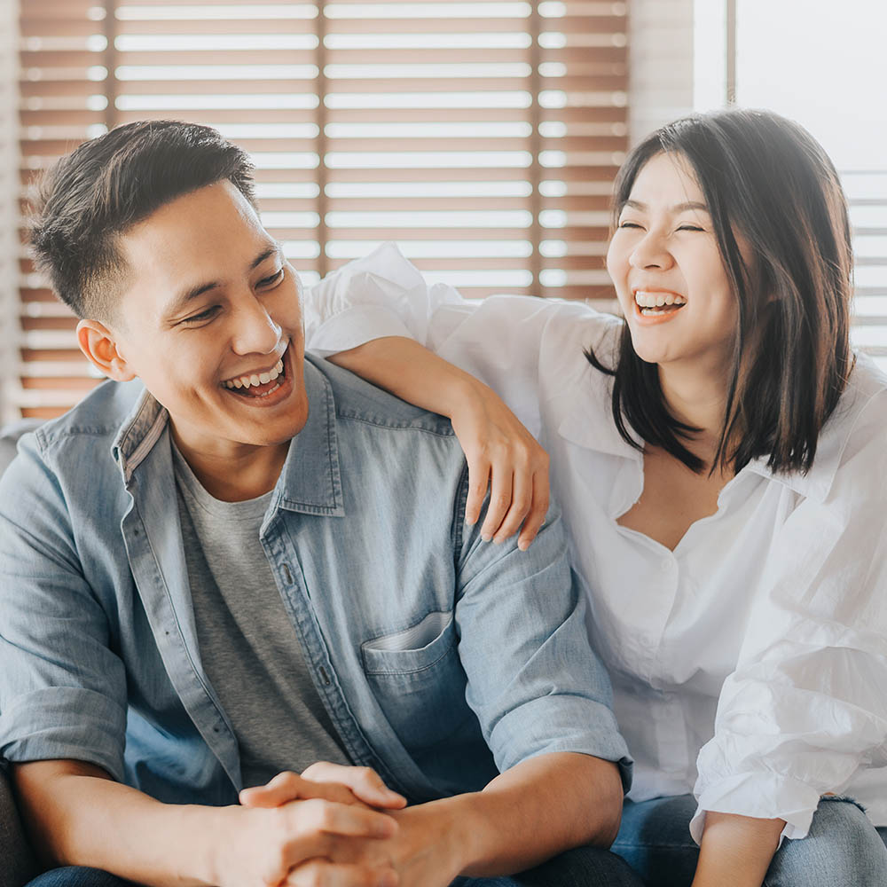 Asian couple having fun and laughing in loving room