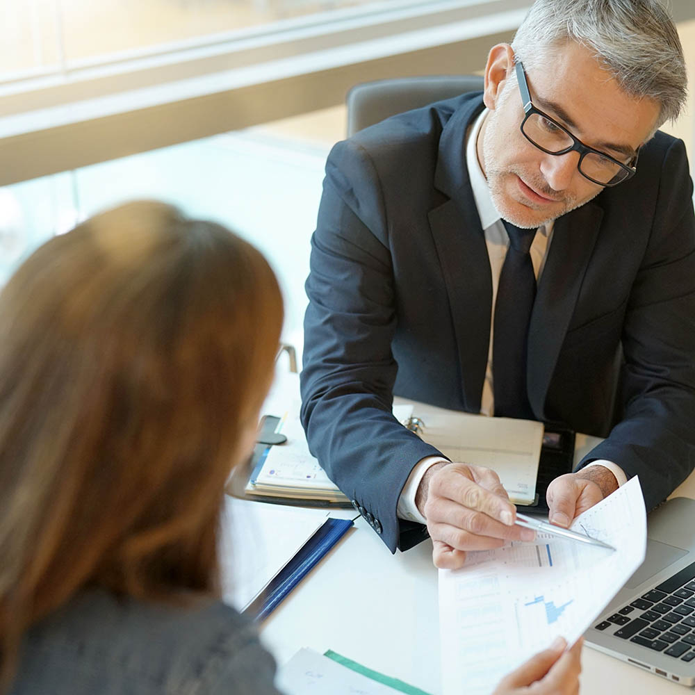 Woman in banker's office signing financial loan for project