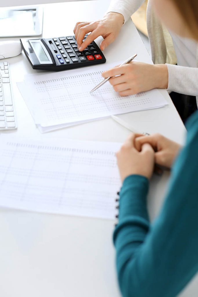 Accountant checking financial statement or counting by calculator income for tax form