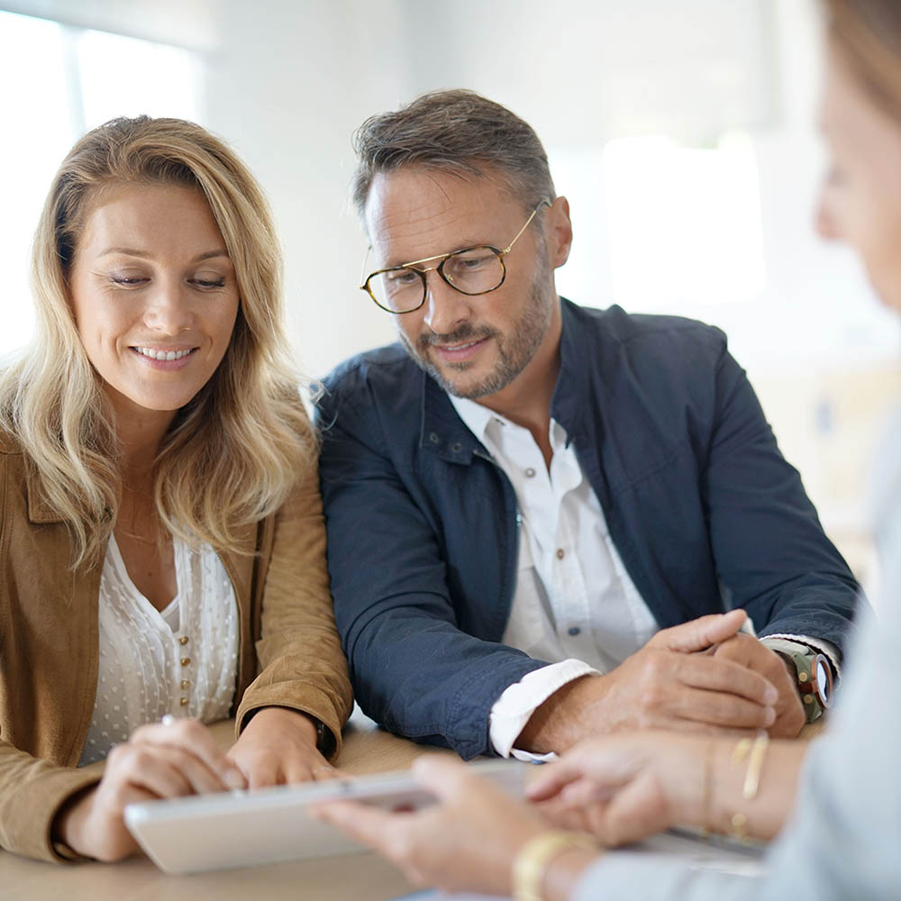 Mature couple meeting real-estate agent in office