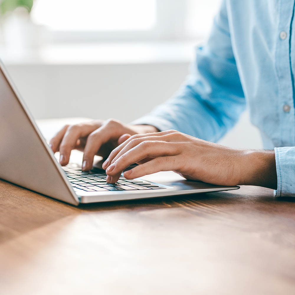 Hands of young contemporary office manager over laptop keypad during work