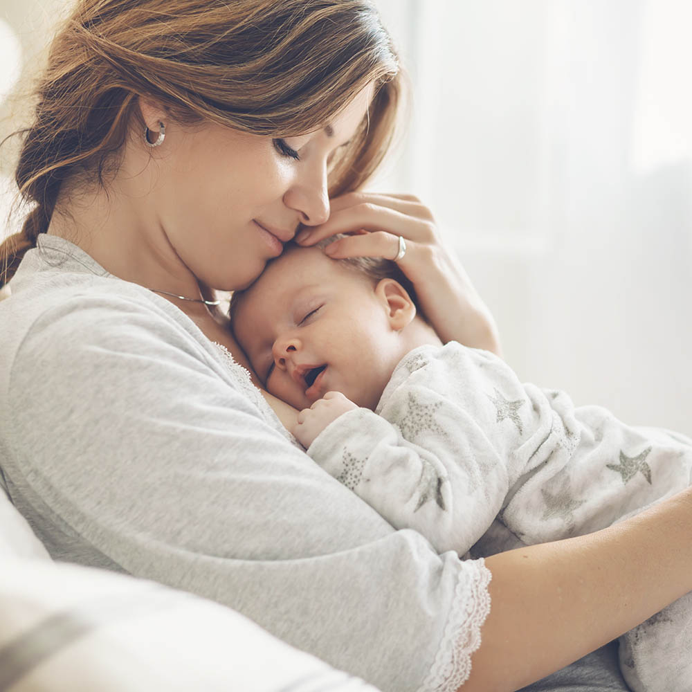 Loving mom carying of her newborn baby at home