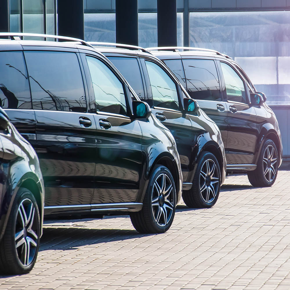 Dark colored passenger vans in a parking lot.